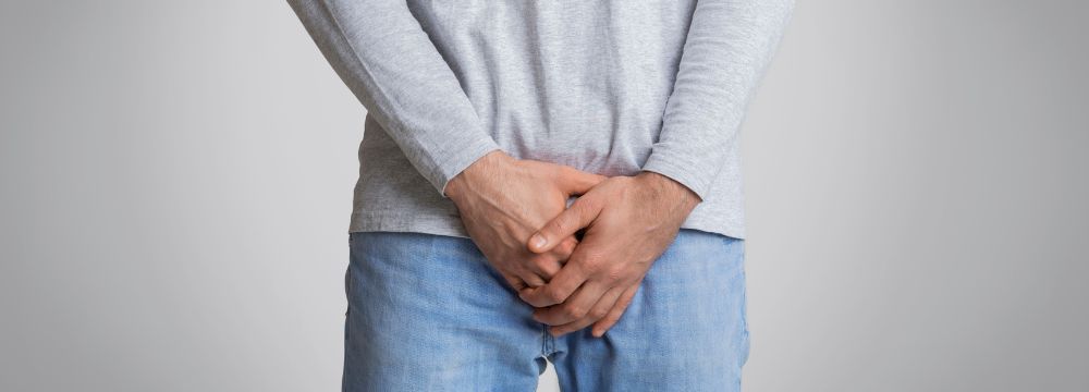 Man holds his groin as he hopes to identify the cause of a painful bulge in the groin as sports hernia