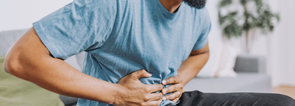 Man grabbing abdomen in pain from gallbladder attack