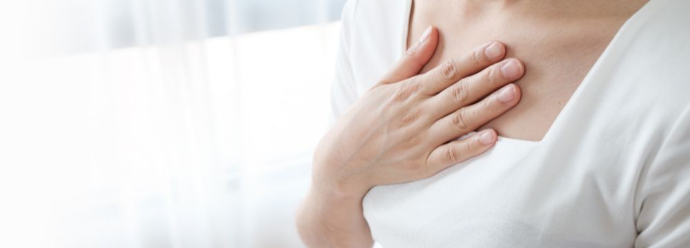 Woman grabbing throat in pain from bile reflux