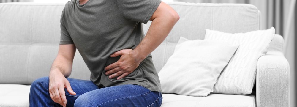 Man holding stomach in hernia pain 
